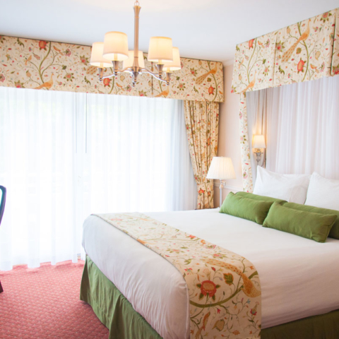 Deluxe King overview, white curtains and floral patterns